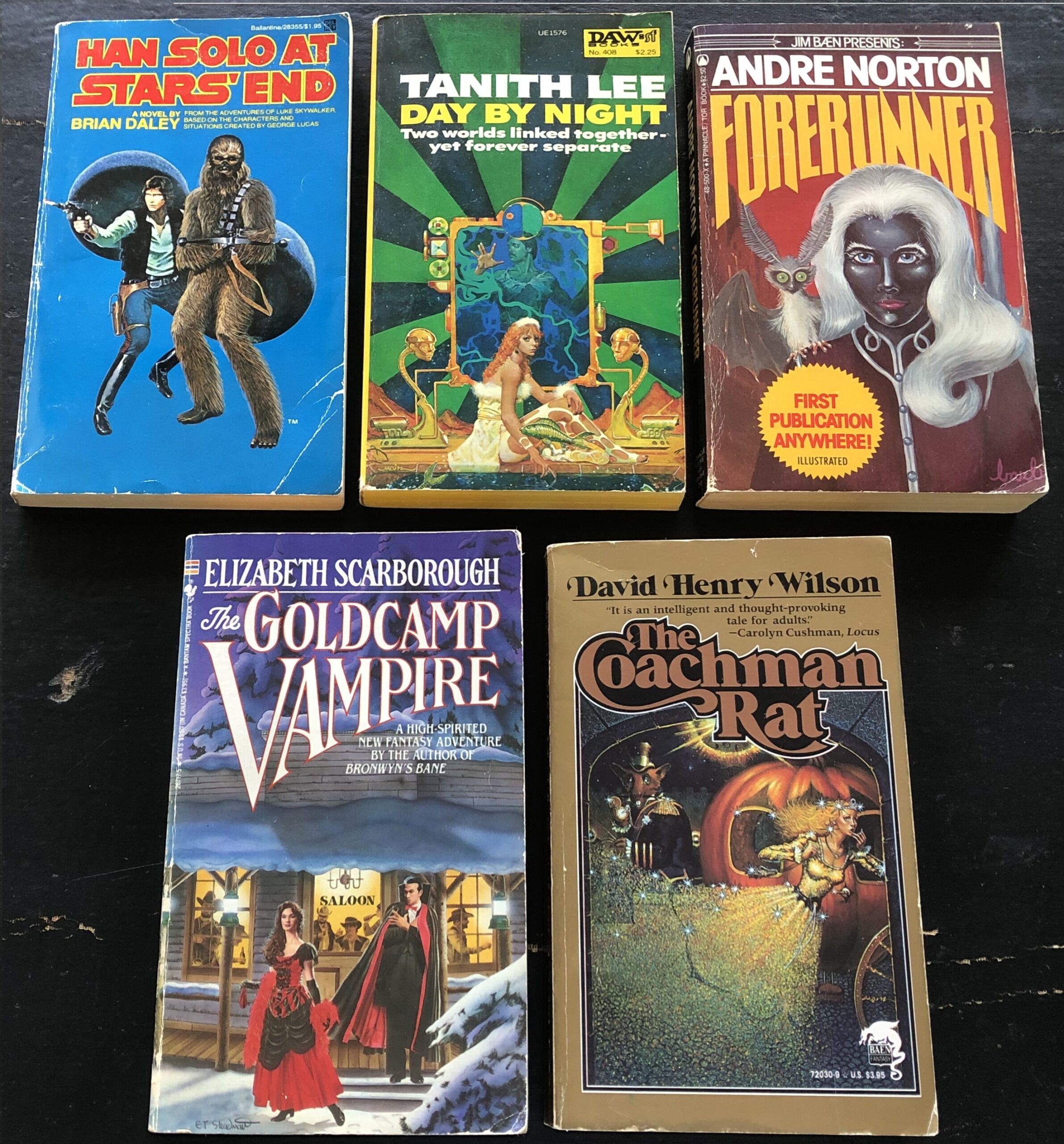 From left to right: Hans Solo at Stars’ End  by Brian Daley, 1979, Del Rey, cover art uncredited; Day by Night by Tanith Lee, 1980, DAW, cover art by Don Maitz; Forerunner by Andre Norton, 1981, “Jim Baen Presents” Tor, cover art and interior illustrations by Barbi Johnson; The Goldcamp Vampire by Elizabeth Scarborough, 1987, Bantam Spectra, cover art by E.T. Steadman; and The Coachman Rat by David Henry Wilson, 1990, Baen, cover art uncredited. Photo by Rosemary Jones, from the author’s collection.