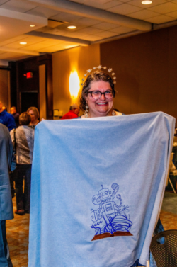 SFWA volunteer Katie Spina shows off some robot art at the finalist reception for the Chicago 2026 Nebulas.
